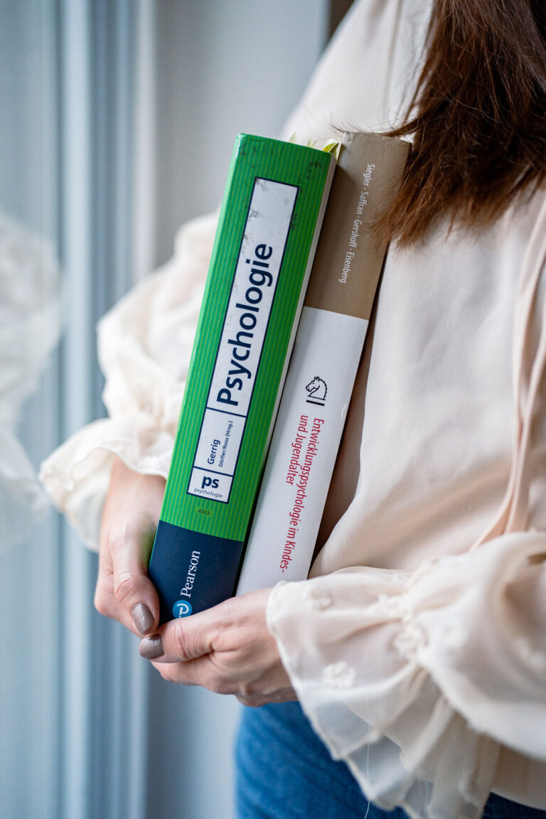 Zwei Psychologie-Fachbücher unter dem Arm